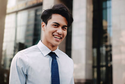 Portrait of smiling businessman standing outside building