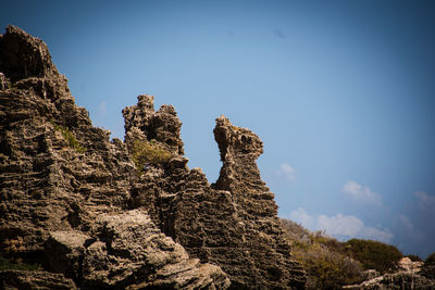 Low angle view of rock formation against sky