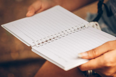 Cropped image of woman holding spiral notebook