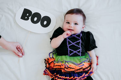 Portrait of cute girl wearing costume lying on bed at home