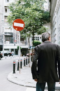 Rear view of a man walking on street