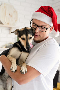 Midsection of woman with dog wearing hat