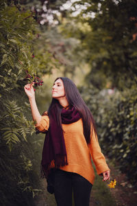 Full length of woman standing against plants