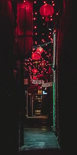 Illuminated lanterns hanging by building at night