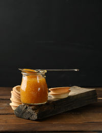 Pike caviar in a glass jar and round tartlets on a black background, close up, copy space