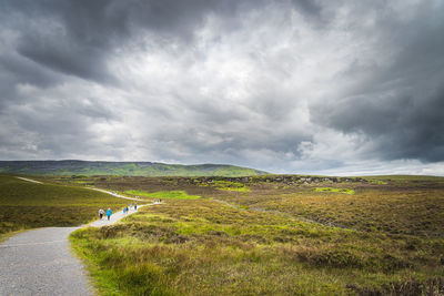 Scenic view of road by land against sky