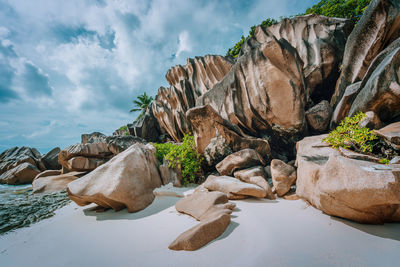 Rock formation by sea against sky