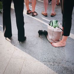 Low section of people standing on sidewalk