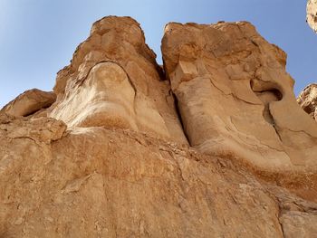 Low angle view of rock formations in desert against clear sky