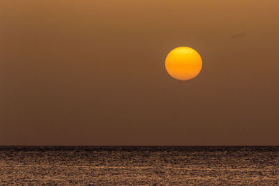 Scenic view of sea against orange sky