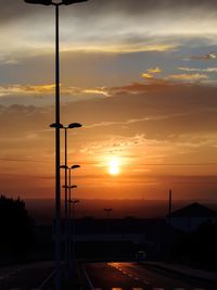 Silhouette street against sky during sunset