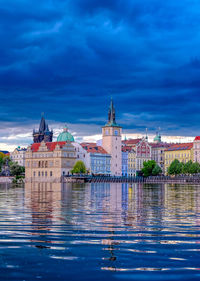 Buildings at waterfront against blue sky