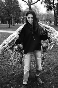 Portrait of young woman dancing with shawl at park