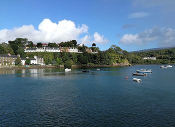 Scenic view of sea by buildings against sky