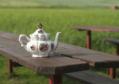 Close-up of teapot on picnic table at park