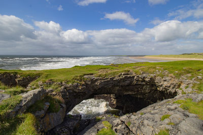 Scenic view of rocky beach against sky