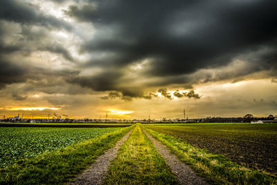 Scenic view of agricultural field against dramatic sky