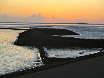 Scenic view of beach against sky during sunset