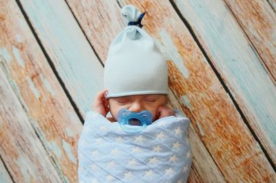 Cute baby boy sleeping on wood