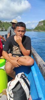 Man sitting in boat against sky