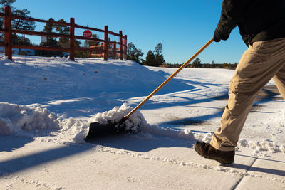 Close up of man removing snow from the street. cold winter day