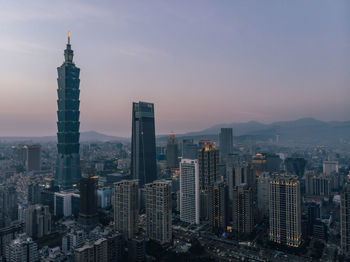 Aerial view of buildings in city at sunset