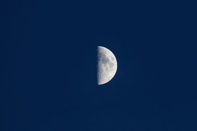 Low angle view of moon against clear blue sky