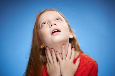 Close-up of young woman against blue sky