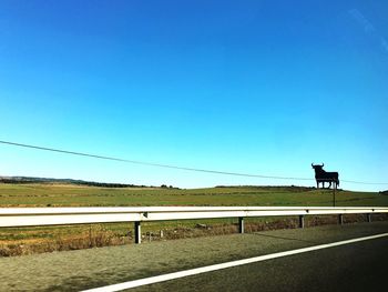 Road against clear blue sky