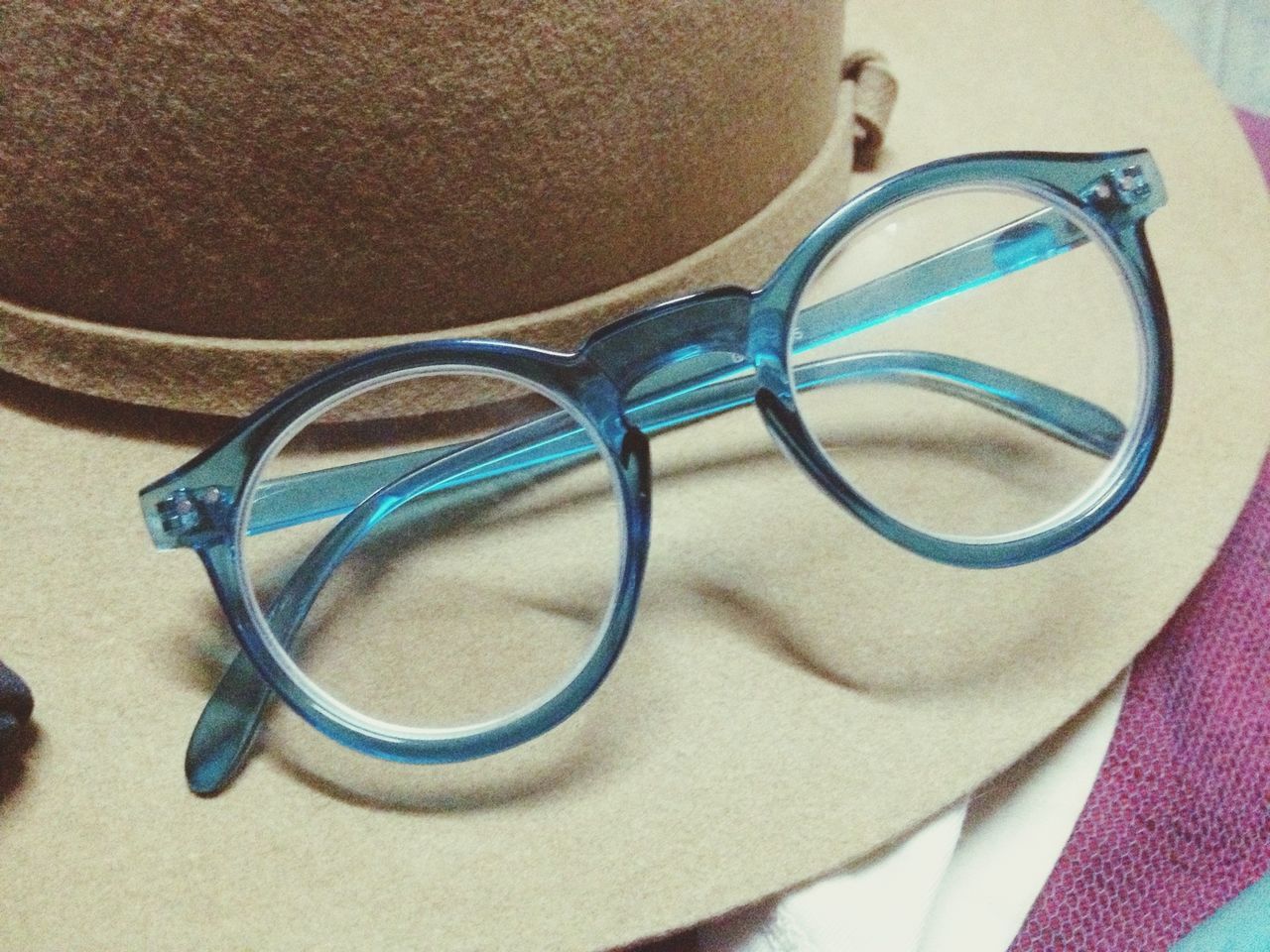 close-up, indoors, sunglasses, still life, high angle view, table, blue, reflection, eyeglasses, day, no people, focus on foreground, part of, shadow, circle, absence, sport, sunlight, transportation, metal