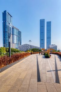 Street and buildings against clear blue sky