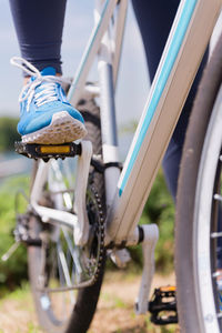 Low section of woman riding bicycle