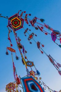 Low angle view of ferris wheel against clear blue sky