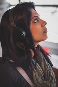 Woman looking away while listening music