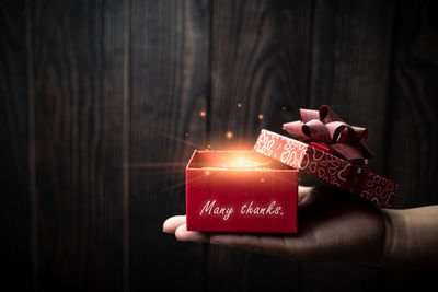 Close-up of hand holding lit candles