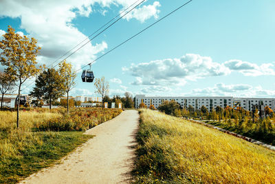 Road amidst grass against sky