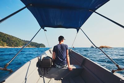 Rear view of man traveling in motorboat on sea