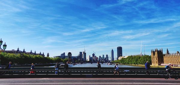 People in city buildings against sky