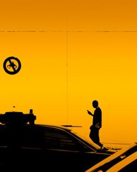 Silhouette man against yellow sky during sunset