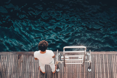 Rear view of man standing by swimming pool