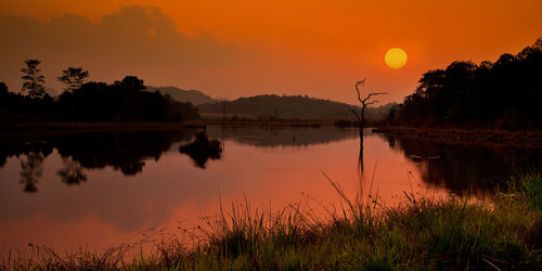 Scenic view of lake against orange sky