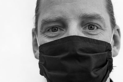 Close-up portrait of man wearing mask against white background