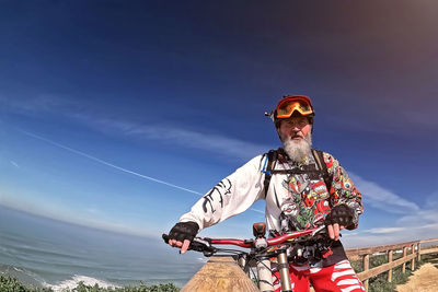 Low angle view of man riding bicycle against sky