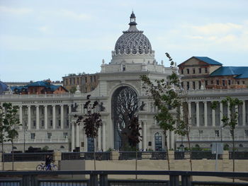 Buildings in city against cloudy sky