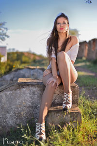 Portrait of smiling young woman standing against sky