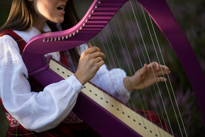 Midsection of musician playing celtic harp