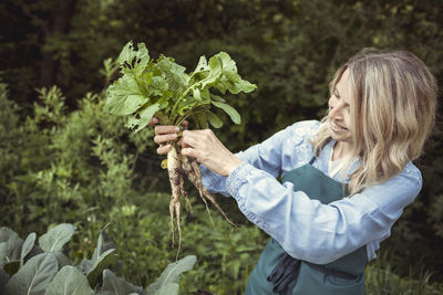 Midsection of woman holding plant