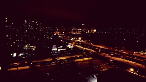 Illuminated cityscape against sky at night