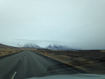 Road amidst landscape seen through car windshield