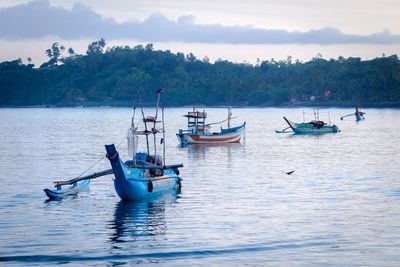 Boats moored on sea against sky